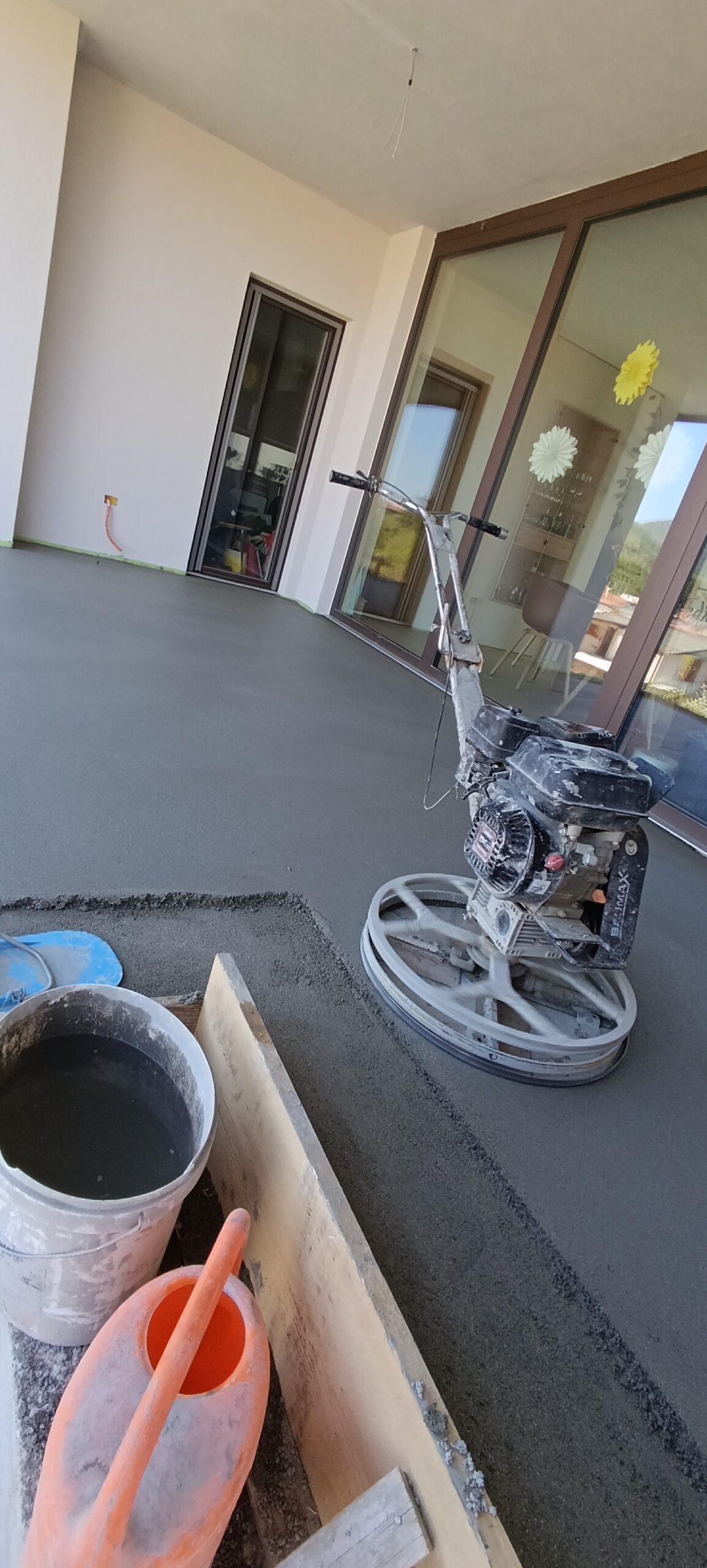 Strojno glajenje cementnega estriha na zunanji terasi z rotacijskim gladilcem